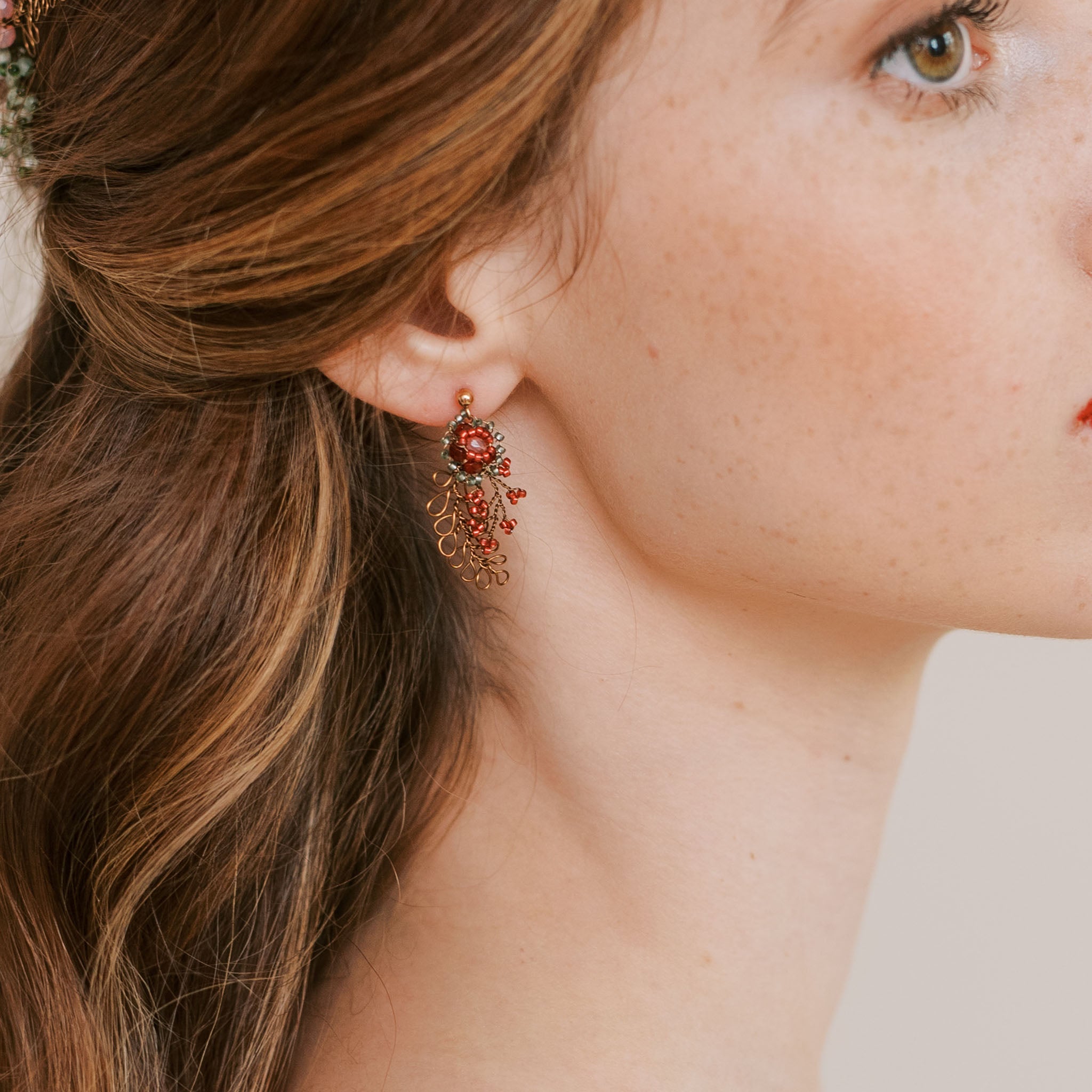 Handmade earrings in bronze wire with red and green beading by Judith Brown Bridal