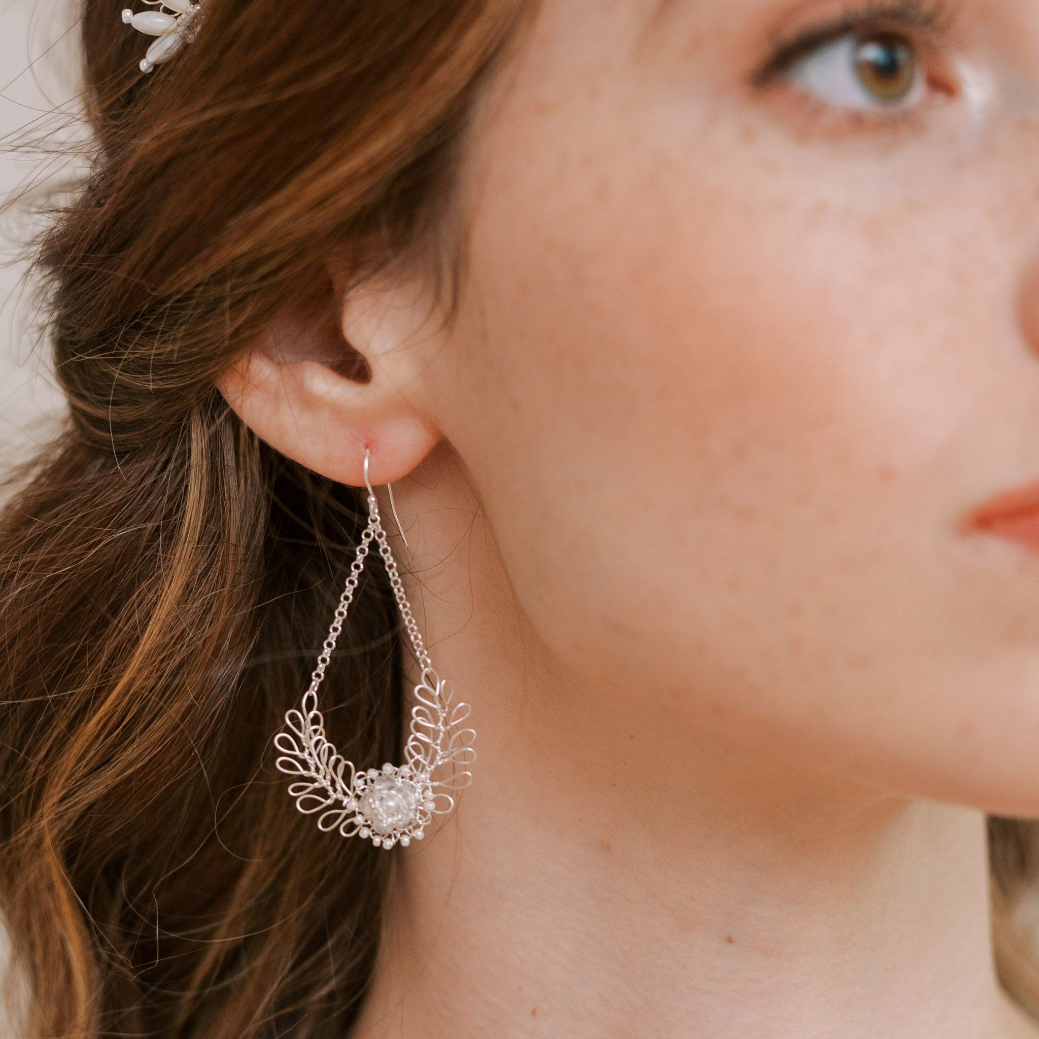 Close up of silver wedding chandelier earrings with pearls by Judith Brown Bridal