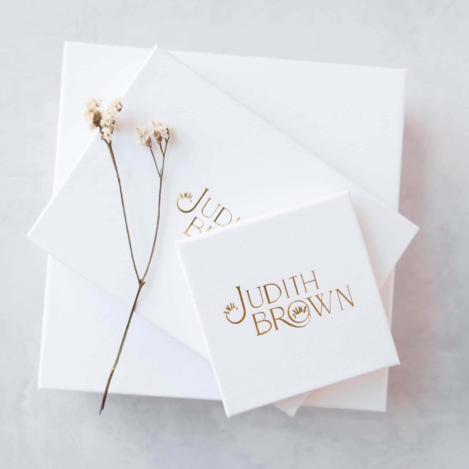 White jewellery boxes with Judith Brown Bridal in gold foil
